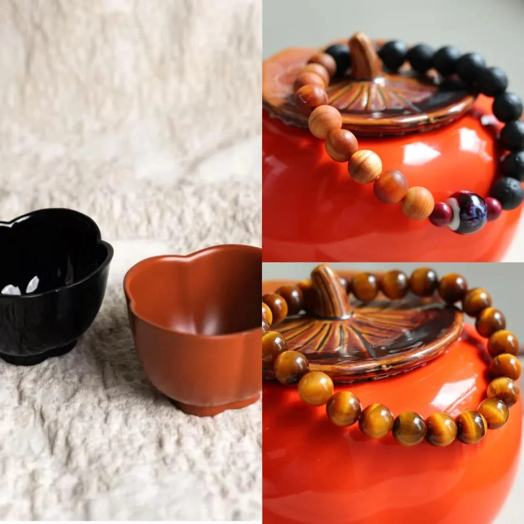 Bracelet of matte black pitted beads and orange-brown wood-grain beads with a blue-and-white patterned bead between two small red beads, resting on an orange ceramic jar.