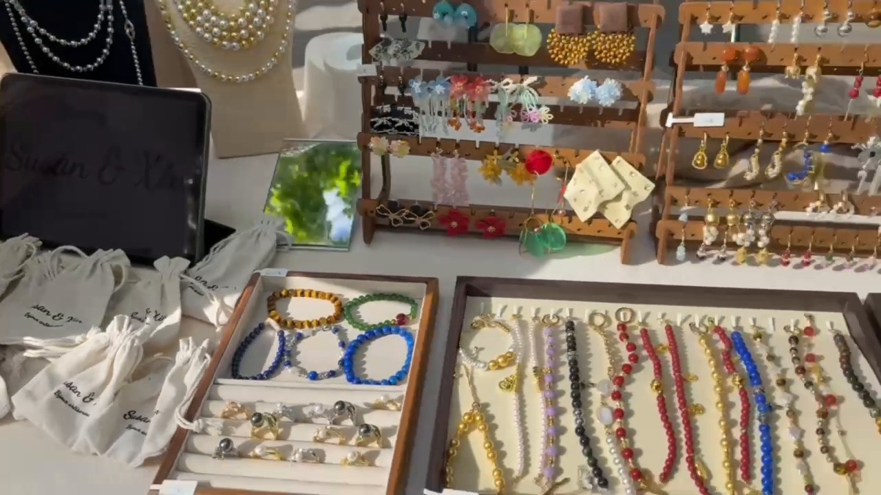 Necklaces, bracelets and earrings arranged on wooden displays at the Paris market.